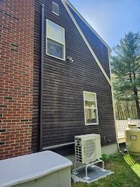 Outdoor ductless heat pump unit beside a home